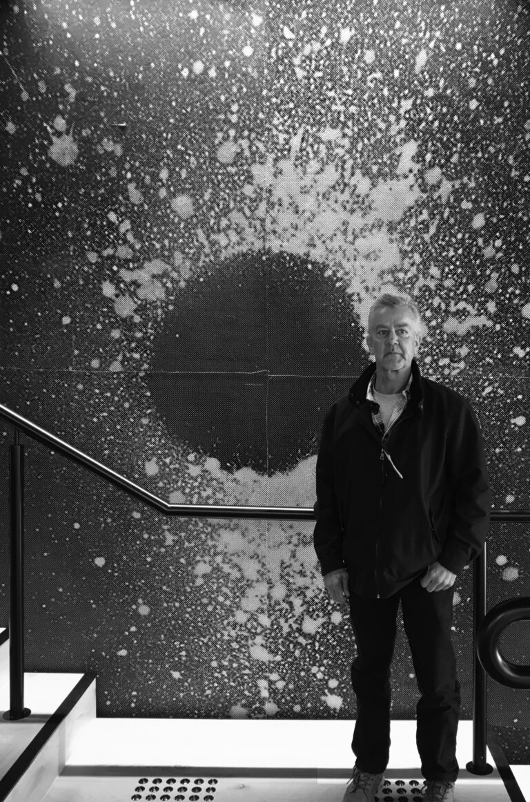 Jack Anselmi standing in front of his charcoal works