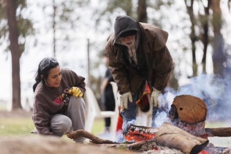 Tending the fire at a KINnected Camp, 2024