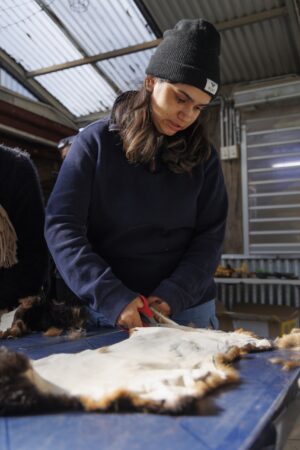 Cutting possum skins at a KINnected Camp, 2024