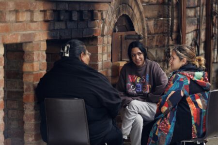Yarning together by the fireplace at a KINnected Camp, 2024