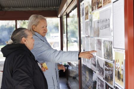 Elders looking over family history photographs at a KINnected Camp, 2024