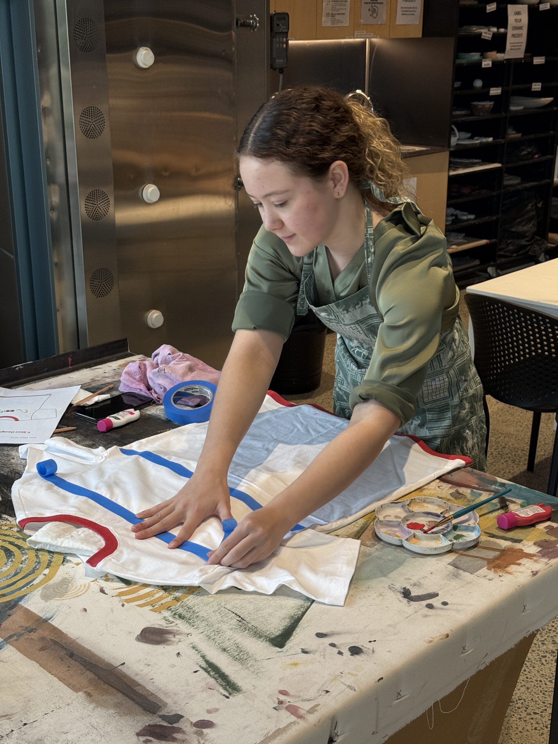 Young artist creating a personalised T-shirt at a Kaiela Arts school holiday workshop