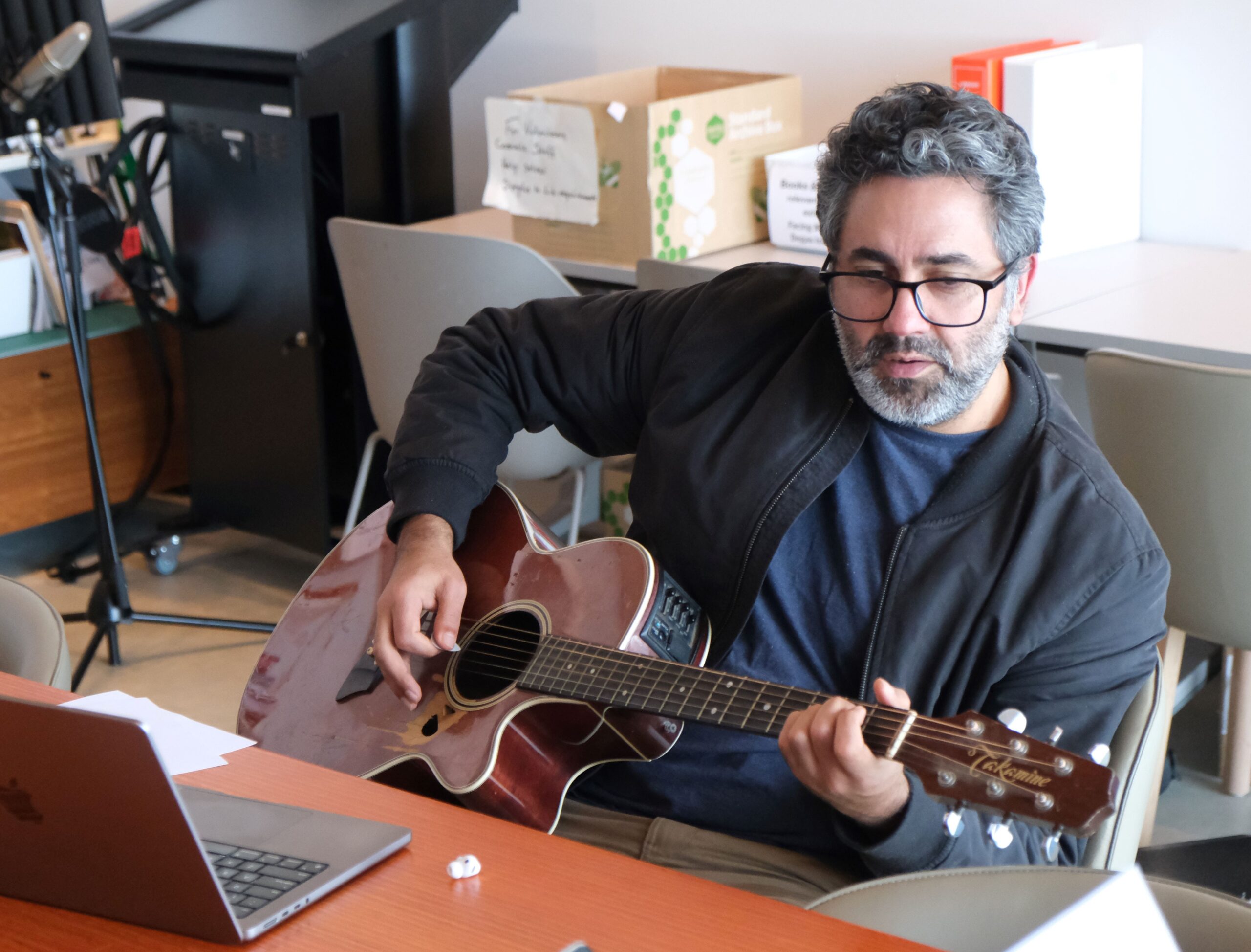 James Henry playing guitar and creating music at a songwriting workshop